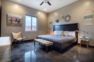 Bedroom with concrete floors and a ceiling fan