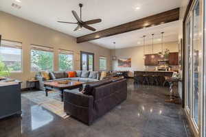 Living room with beamed ceiling, ceiling fan, recessed lighting, and concrete floors