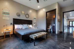 Bedroom with finished concrete floors, recessed lighting, ceiling fan, and ensuite bathroom