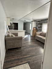 Living area with dark wood-style floors and a textured ceiling