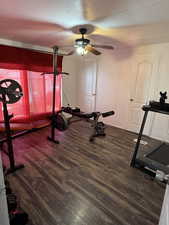 Workout area featuring dark wood-style flooring