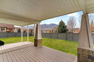 Deck with a mountain view, a fenced backyard, and a residential view