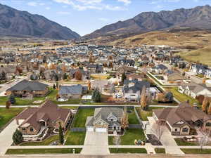 Aerial view of property and surrounding area with mountains and nearby suburban area