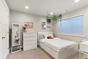Carpeted bedroom with recessed lighting