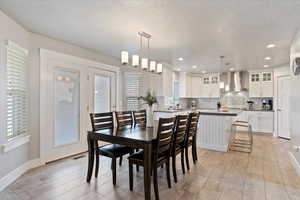 Dining space featuring light wood-style flooring, a textured ceiling, and recessed lighting