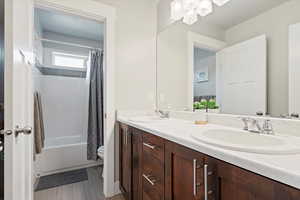 Full bath with double vanity and shower / bathtub combination with curtain