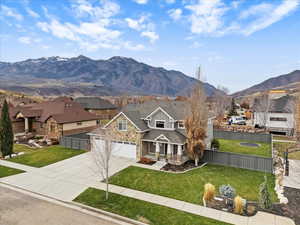 View of front of property with a porch, concrete driveway, a mountain view, a residential view, and a garage