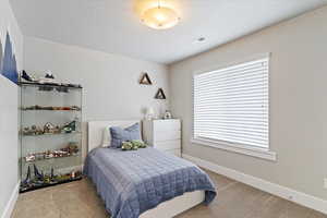 Carpeted bedroom with baseboards and a textured ceiling
