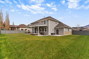 Back of property with a fenced backyard, a patio, and a wooden deck