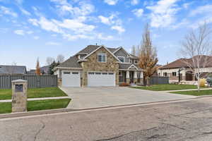 Craftsman-style home featuring stone siding, concrete driveway, a porch, and a shingled roof