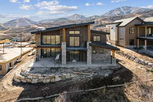 Back of property featuring a mountain view, a patio, and board and batten siding