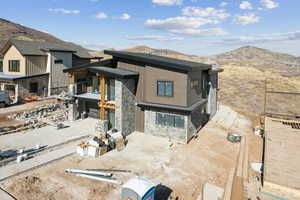 View of front of house with stone siding and a mountain view