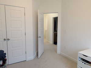 Bedroom featuring light colored carpet and a closet