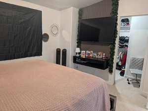 Carpeted bedroom featuring a walk in closet and a textured ceiling