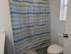 Bathroom with a shower with curtain and toilet