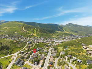 Aerial overview of property's location with a mountainous background and nearby suburban area