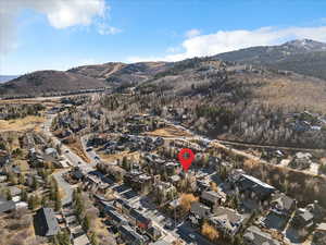 Aerial view of property's location with a mountainous background and nearby suburban area