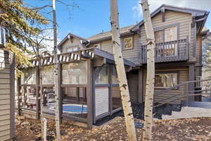Rear view of property with a sunroom and a shingled roof