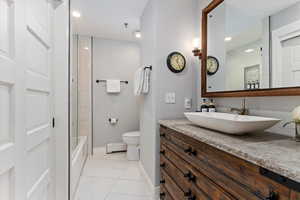 Bathroom featuring light tile patterned floors, vanity, baseboard heating, shower / bathtub combination, and recessed lighting