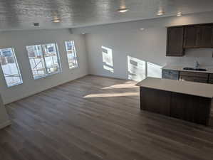 Living room with a textured ceiling and dark wood-style flooring