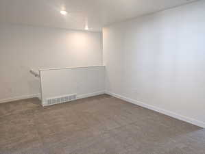 Spare room featuring carpet floors and baseboards