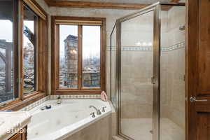 Bathroom featuring a whirlpool tub, a shower stall, and vanity