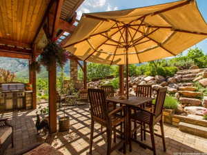 View of patio with outdoor dining area and exterior kitchen