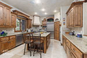 Kitchen featuring light stone counters, brown cabinets, decorative backsplash, stainless steel appliances, and recessed lighting