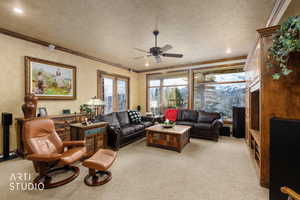 Living area with ornamental molding, light colored carpet, a ceiling fan, and recessed lighting