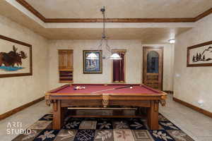Recreation room with billiards table and a textured wall
