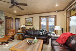 Living room featuring carpet, crown molding, a ceiling fan, and recessed lighting