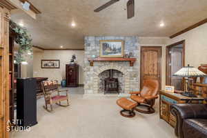 Living room featuring crown molding, recessed lighting, light colored carpet, a wood stove, and ceiling fan