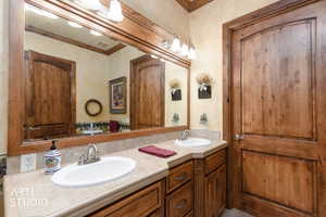 Bathroom featuring crown molding and double vanity