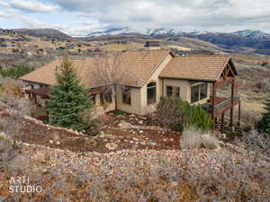View of front of property with a mountain view, stucco siding, a chimney, and a tile roof