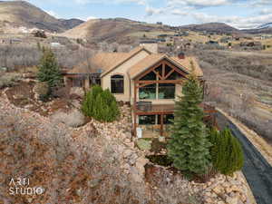 Rear view of property with a chimney, stucco siding, and a deck with mountain view