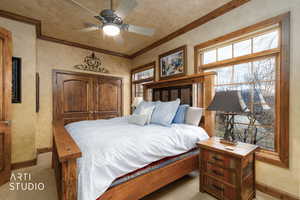 Bedroom featuring multiple windows, crown molding, ceiling fan, and a textured wall