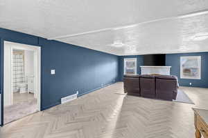 Home theater room with a textured ceiling and baseboards