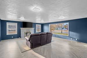Cinema room featuring a brick fireplace and a textured ceiling