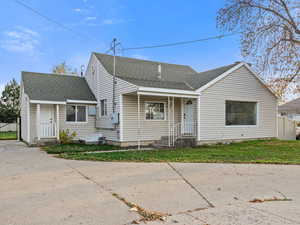 Bungalow-style home featuring roof with shingles and concrete driveway