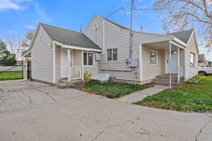 View of front of home with roof with shingles and a gate