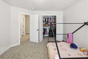 Bedroom with light colored carpet and baseboards