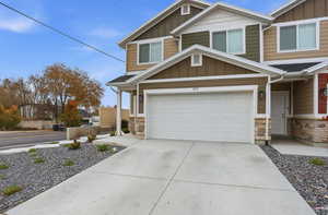 Craftsman-style house with board and batten siding, stone siding, concrete driveway, and a garage