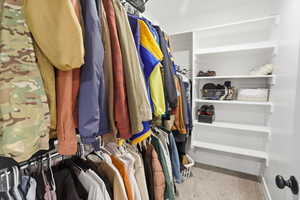 Spacious closet featuring light colored carpet