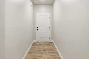 Doorway with baseboards and wood finished floors