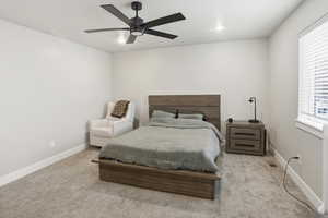 Carpeted bedroom with a ceiling fan and recessed lighting