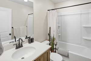 Bathroom featuring shower / bath combination with curtain and vanity