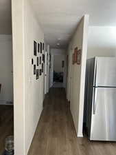 Corridor with dark wood-type flooring and baseboards