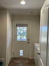Doorway featuring wood finished floors and washing machine and clothes dryer