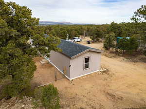 Aerial view of property and surrounding area featuring a forest