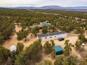 View from above of property featuring a heavily wooded area and a mountainous background